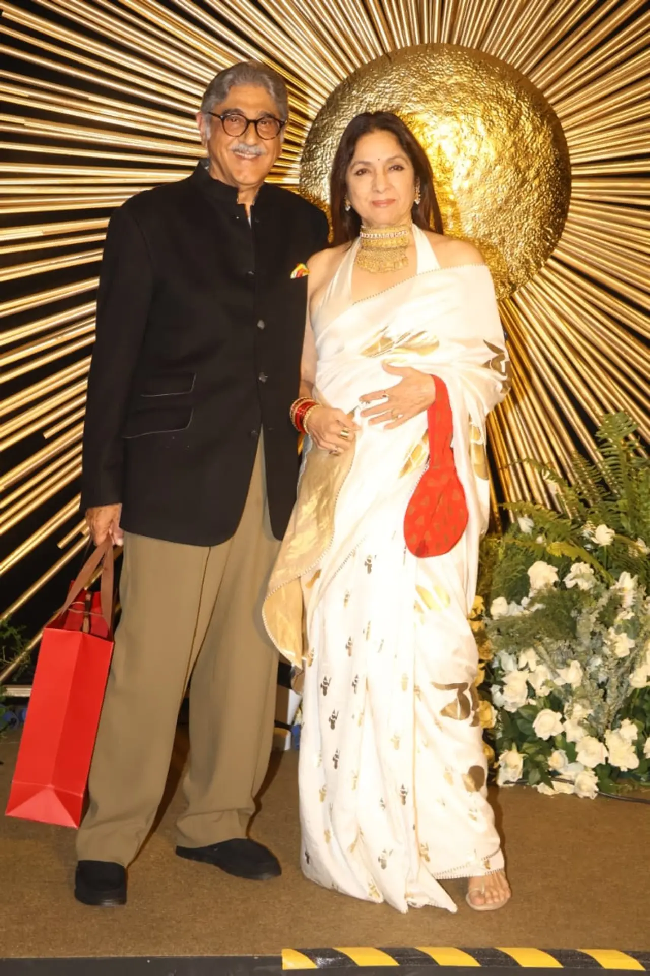 Neena Gupta attended Vijay–Rashmika’s reception with husband Vivek Mehra, making an elegant appearance together. Neena looked glam in a white saree adorned with gold motifs, paired beautifully with a statement gold choker necklace.